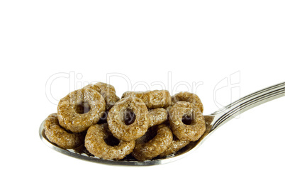 Sweet brown rings on teaspoon isolated on white