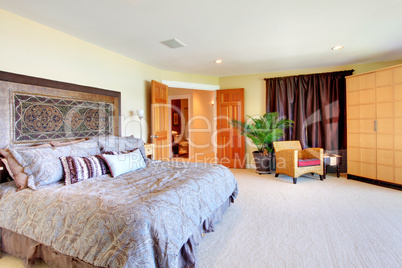 Large yellow master bedroom with open doors and huge bed.