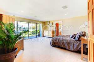 Large yellow master bedroom with open doors and huge bed.