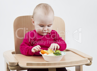 young child eating in high chair