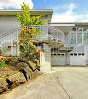 Grey large modern house exterior with huge parking area.