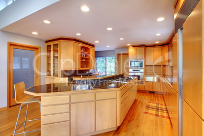 Large luxury modern wood kitchen with granite counter tops.