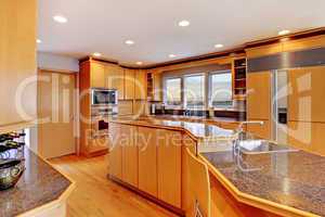 Large luxury modern wood kitchen with granite counter tops.