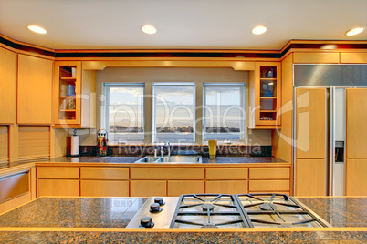 Large luxury modern wood kitchen with granite counter tops.