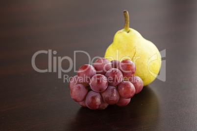 pear and grapes lying on a wooden table