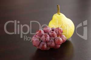 pear and grapes lying on a wooden table