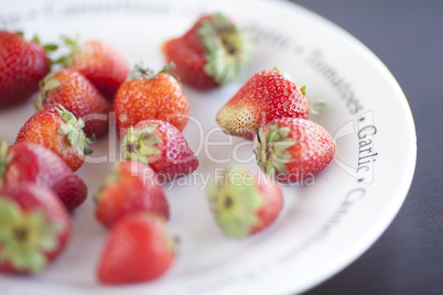 strawberries on a plate on a wooden table