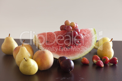 watermelon, strawberry, grape, plum and pear lying on a wooden t