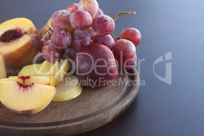 peach, pear and grapes on a cutting board