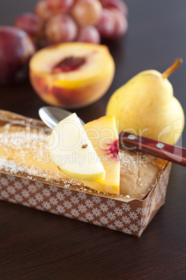 peach, pear, plum, coconut cake,spoon and grapes on a wooden tab