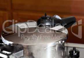 Pressure being released from cooker on hob