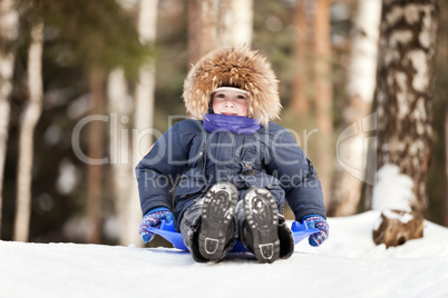 Child sled on snow hill