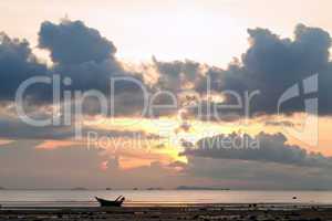 Sunset with boat in the sea, cloudy sky