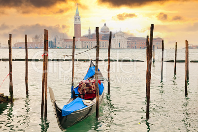 Gondola at sunset pier near in Venice, Italy