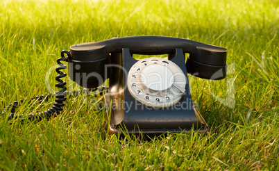 Retro styled rotary telephone on grass