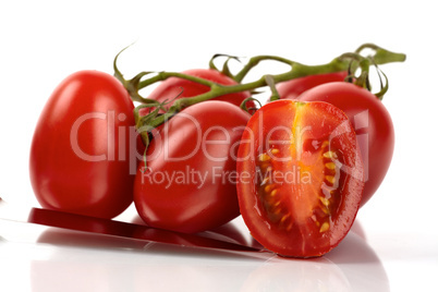 Frische Roma Tomaten mit Messer vor weißem Hintergrund