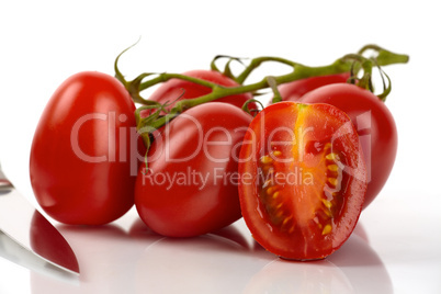 Frische Roma Tomaten mit Messer vor weißem Hintergrund