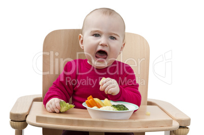 young child eating in high chair