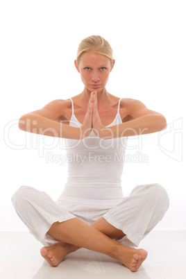 a young caucasian woman dressed in white sitting cross-legged do