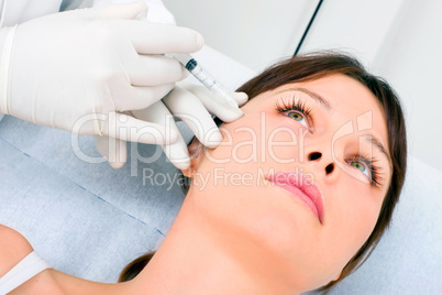 young caucasian woman receiving an injection of botox from a doc