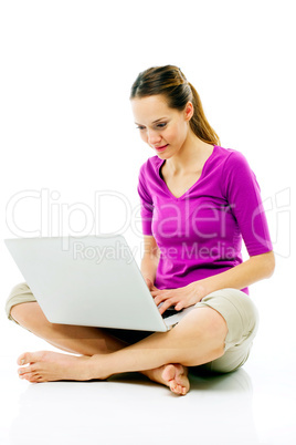 Young woman sitting on the floor with laptop on white background