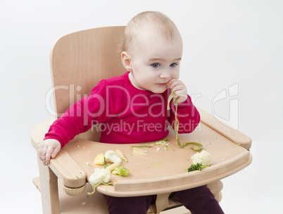 young child eating in high chair