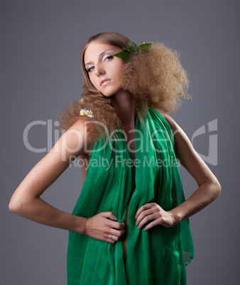 Young cute girl with leaves and camomile in hair