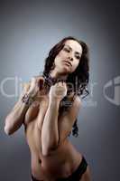 Young naked woman stand and close breast by hands