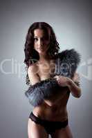 Young naked woman stand and close breast by fur