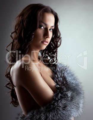 Amazing nude woman hiding breast by fur