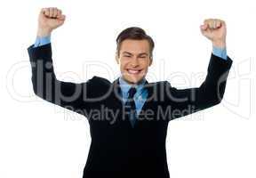 Businessman celebrating success with arms up