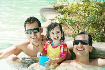 Happy family having fun in swimming pool.  Brothers and niece ha
