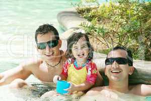 Happy family having fun in swimming pool.  Brothers and niece ha