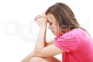 Young woman praying sincerely with her hands folded and eyes clo