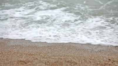 Young girl walking on the beach with waves