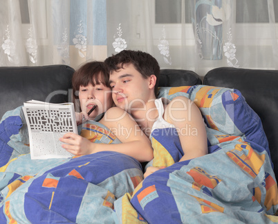 Young couple solving a crossword puzzle