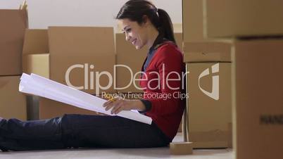 Woman reading plans of new house during move