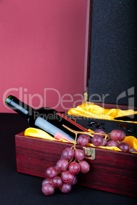 Weinflasche in dekorativer Geschenkbox mit Weintrauben dekoriert
