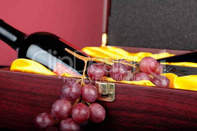 Weinflasche in dekorativer Geschenkbox mit Weintrauben dekoriert