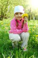 The little girl among dandelions