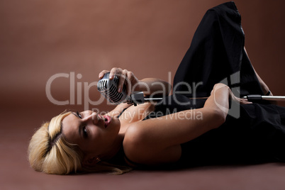 pin-up woman lay on brown with microphone