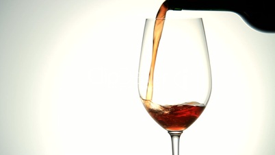 Rotwein wird in ein Glass gefüllt
