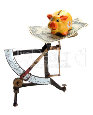 scales with dollar notes and piggybank