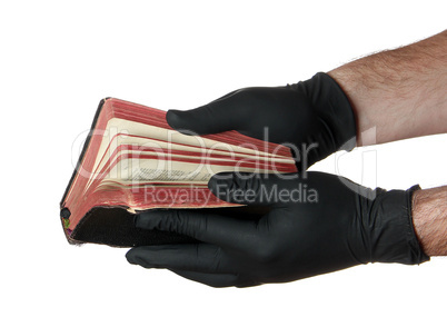 old book in hands with black gloves