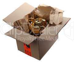 golden piggybank in cardboard box with brown paper