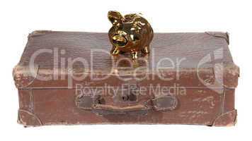 old brown suitcase with golden piggy bank