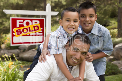 Hispanic Father and Sons in Front of Sold Real Estate Sign