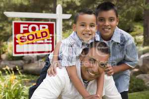 Hispanic Father and Sons in Front of Sold Real Estate Sign