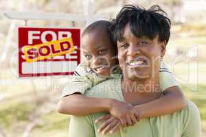 Mother and Child In Front of Sold Real Estate Sign