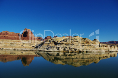 Red and white rock reflection in Colorado River near Hite, Utah